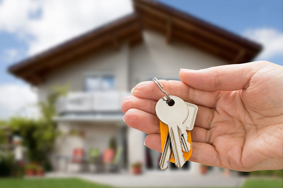 Nahaufnahme einer Person, die den Hausschlüssel in der Hand hält